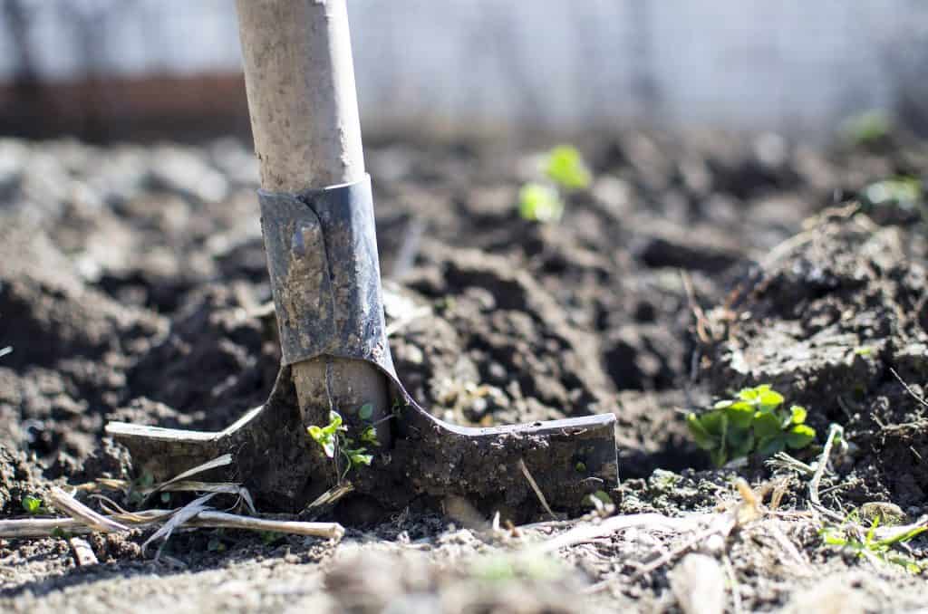 A shovel digging up some soil
